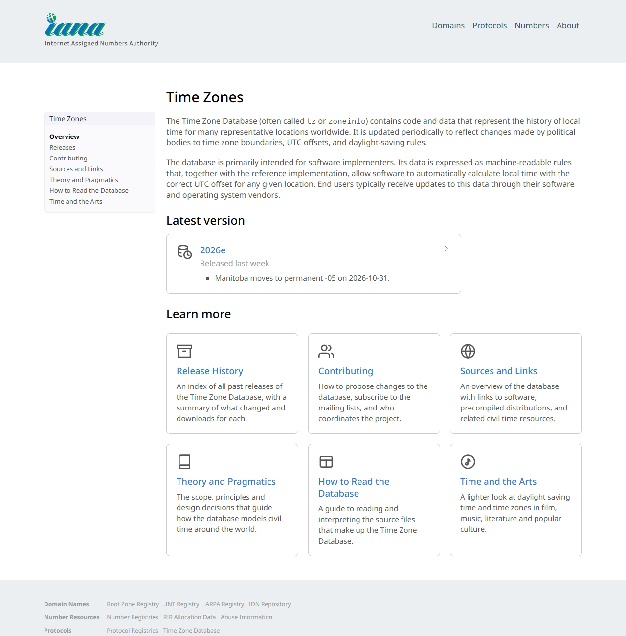 IANAのTime Zonesのページの画面。タイムゾーンデータベースは世界中の代表的な地点の現地時刻の歴史を表すコードとデータを含み、政治的な機関によるタイムゾーン境界・UTCオフセット・夏時間規則の変更を反映して定期的に更新されると説明され、Latest versionとして2026eが表示されている